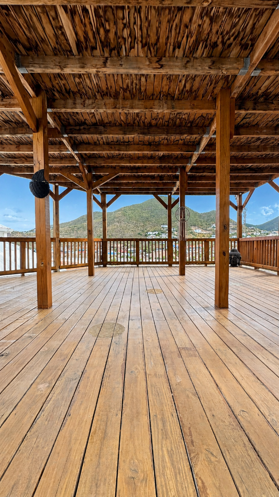 Deck de yoga en bois au sommet de la résidence IDOLEM avec panorama sur les mornes