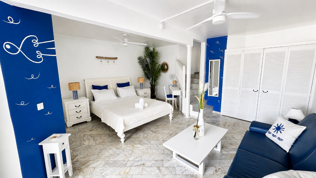 Pièce principale lumineuse avec fresque bleue et vue sur la terrasse, Blanc Bleu