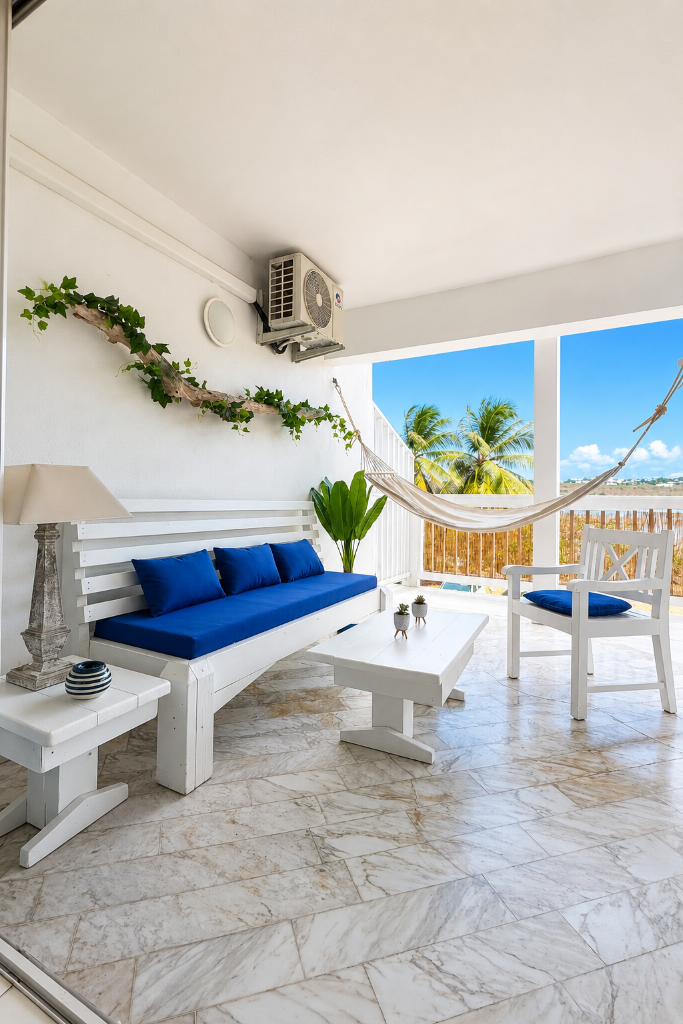 Terrasse avec salon bleu, hamac et vue dégagée sur les palmiers — Blanc Bleu Saint-Martin